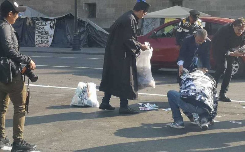 Activistas lanzan billetes en el Zócalo como protesta por funcionarios corruptos.