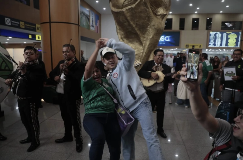 Con mariachi y bailes, mexicanos reciben en el AICM al turismo mundialista